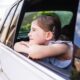 child looking out the car window.